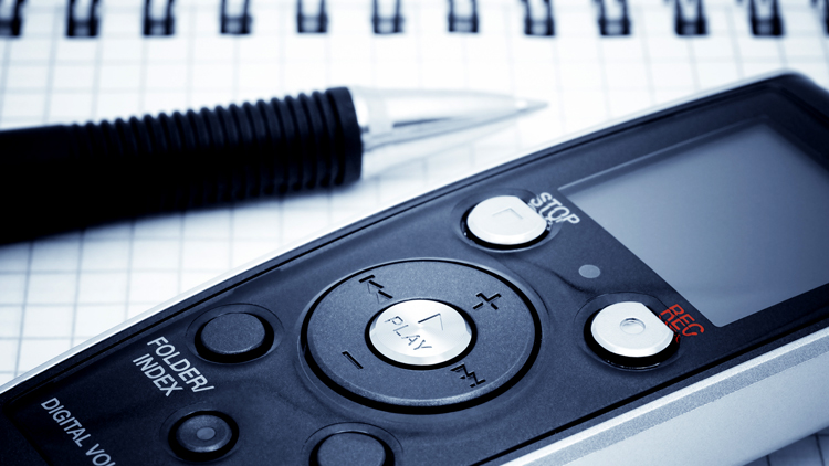 Voice recorder on table next to pen