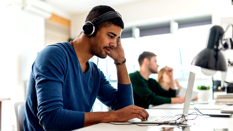 Man sitting at desk with headphones
